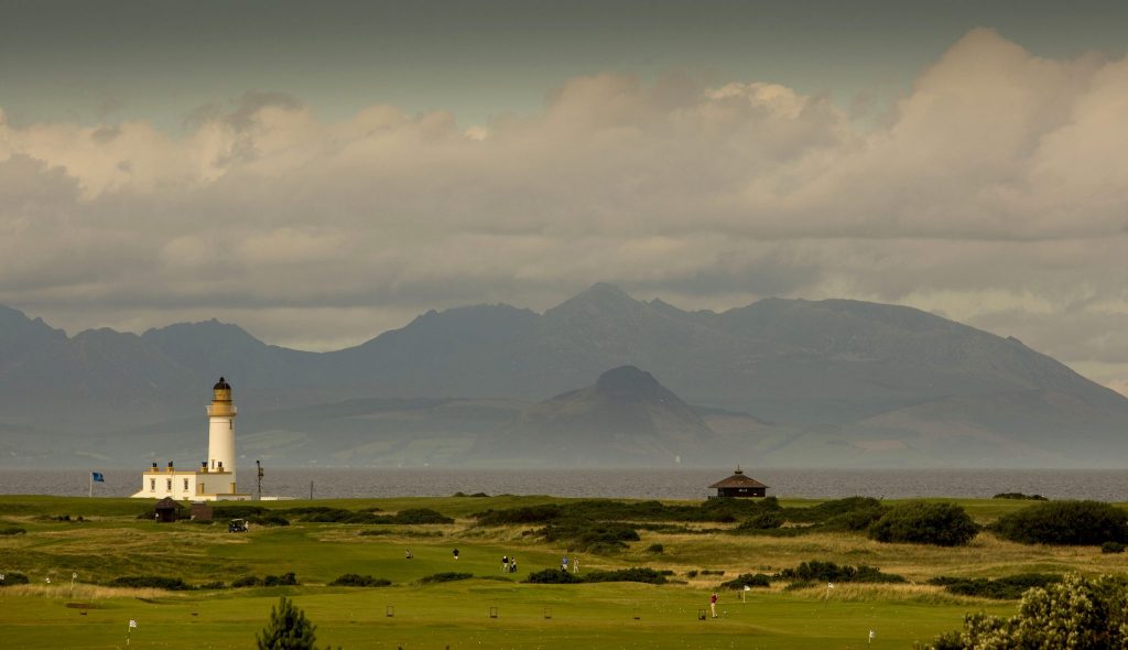 An image of Trump Turnberry golf course with its iconic lighthouse in the distance