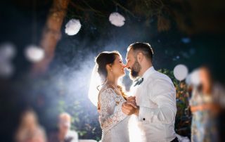 A newlywed couple takes their first dance at night